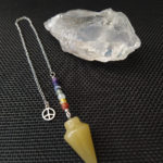 Pendule avec pointe en calcite miel surmontée d'un chapelet 7 chakras